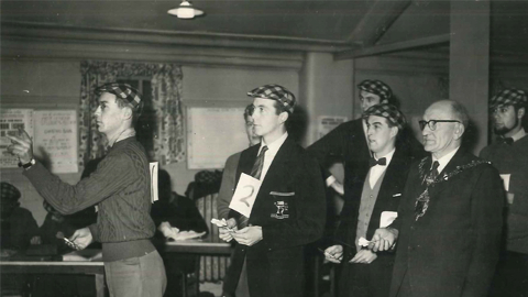 A black and white image showing alumni from 1960 playing darts.